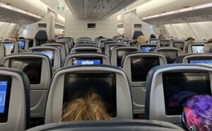 Economy class aboard Delta A330neo with rows of seats and IFE screens in view